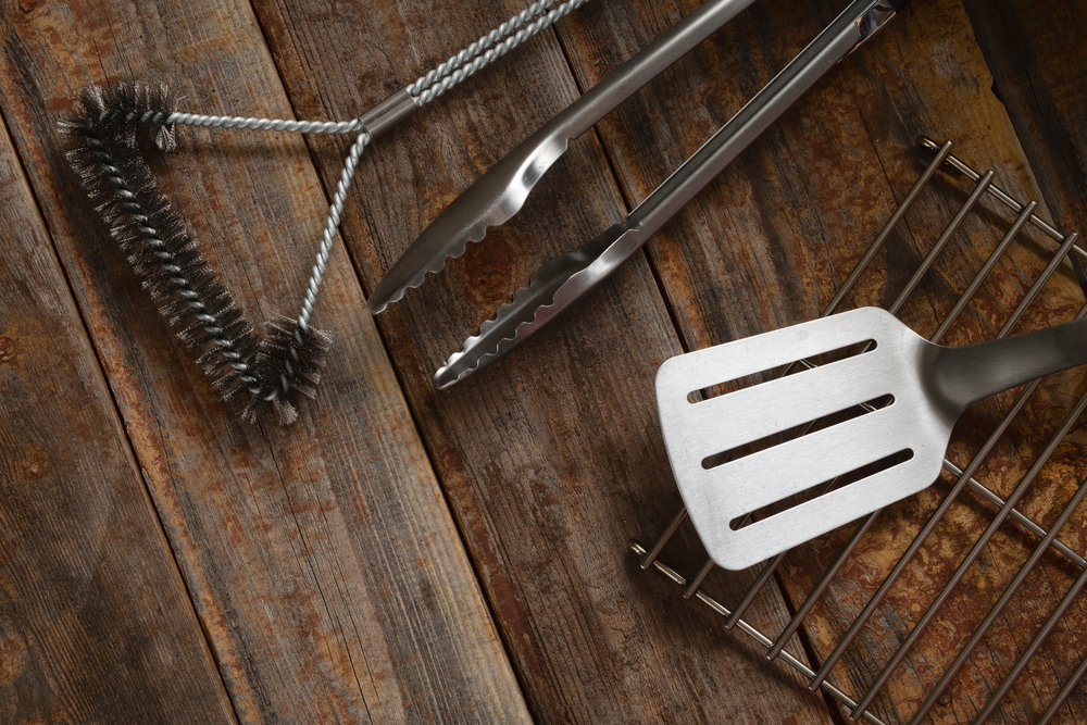 Various BBQ accessories and tools on a wooden tabletop.