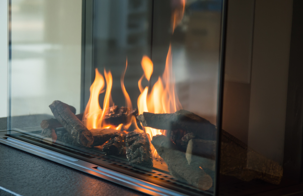 A close up of the flames behind glass in a gas fireplace.