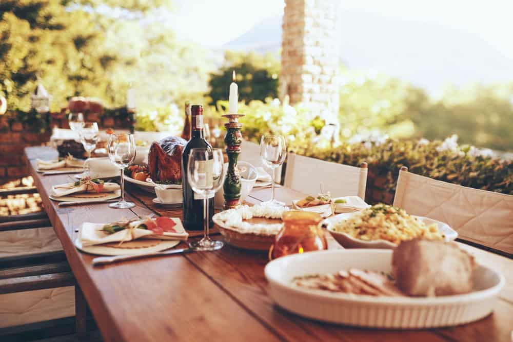 A backyard table beautifully setup with plates and food ready for a Christmas BBQ feast.