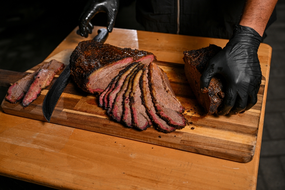Slow and low cooked meat being sliced. Just one example of Autumn BBQ recipes in Australia. 