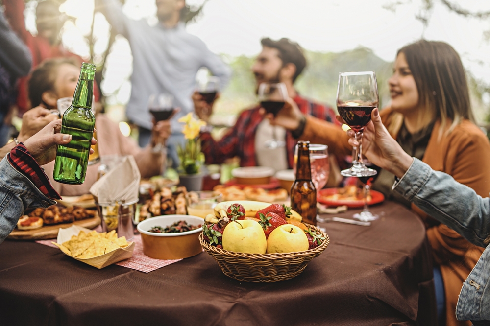 A group sitting around a table embracing autumn outdoor entertaining in Australia.