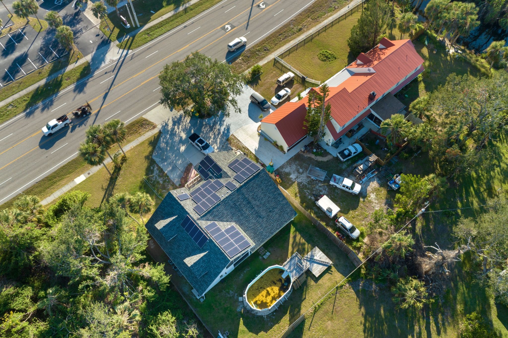alt text: An aerial view of a residential home equipped with extensive solar panel arrays on the roof to harness renewable energy.
