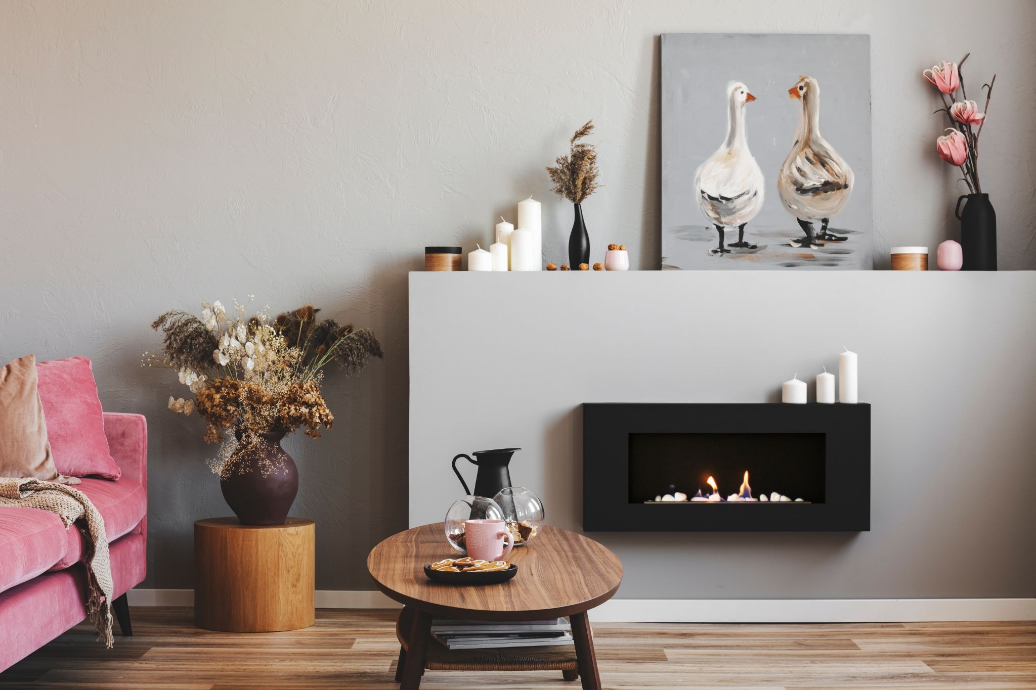 A sleek, wall-mounted black gas fireplace provides a warm glow in a modern, stylishly decorated living room.