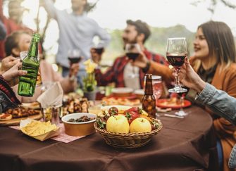 A group sitting around a table embracing autumn outdoor entertaining in Australia.